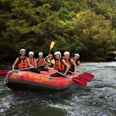 a group of people riding on the back of a boat in the water